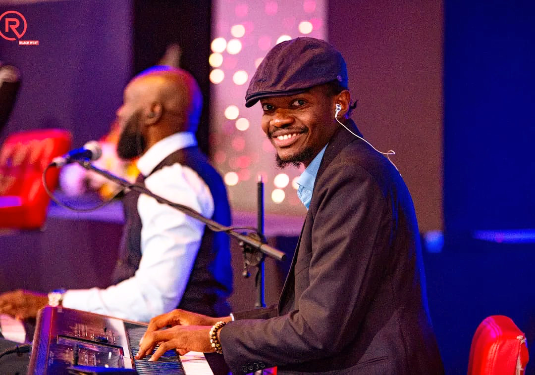 Intare smiling at the piano during a live worship session